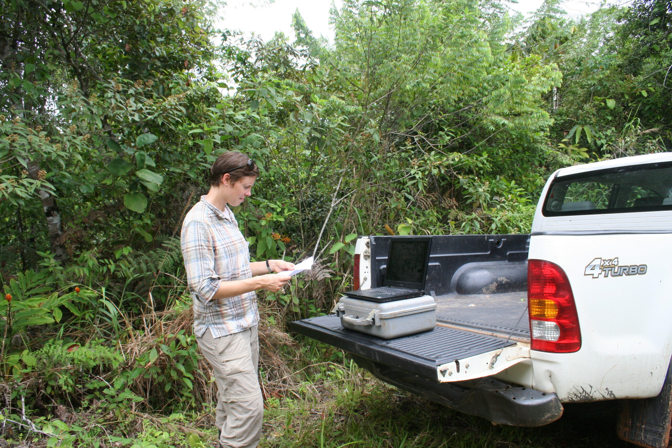 Cary Institute scientist Dr. Sarah Batterman uses a map to locate a plot in the ten-year-old forest behind her.