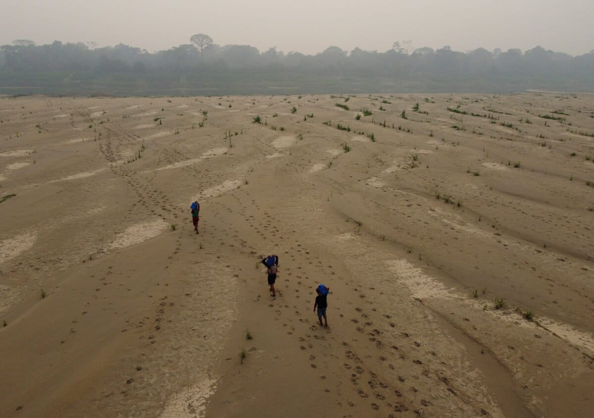 Residents transport drinking water from Humaita to the Paraizinho community, along the dry Madeira River, a tributary of the Amazon River, amid a drought, in Amazonas state, Brazil, Sunday, Sept. 8, 2024. (AP Photo/Edmar Barros)