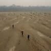 Residents transport drinking water along the dry Madeira River, a tributary of the Amazon River, during the dry season, in 2024. Image by AP Photo/Edmar Barros.