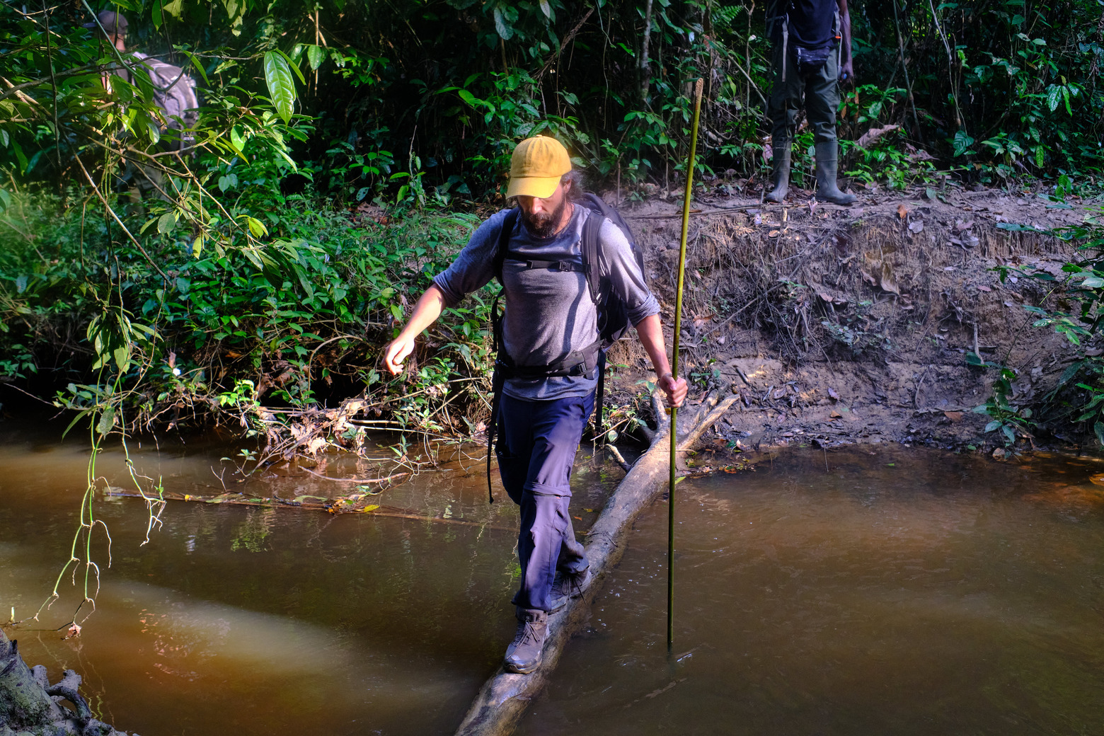 Mongabay Producer Juan Maza crosses a river in the proposed Kwa National Park in Grand Gedeh, Liberia. Photo by Ashoka Mukpo for Mongabay.