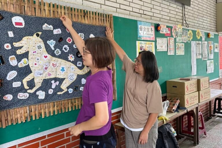 Siraya-language teachers Silia Pan, left, and Uma Talavan hang a tapestry made by students at Koupi Experimental Elementary School, in Tainan, Taiwan, on Aug. 21, 2026. Image by Aylin Ho for Mongabay.