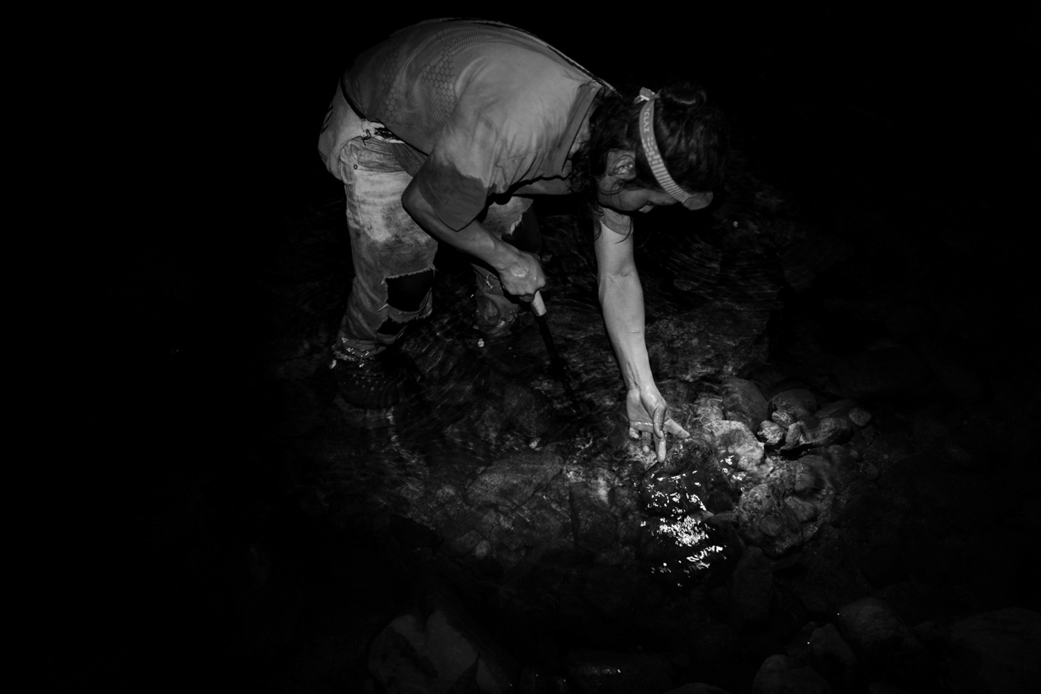 A young Wiwa man fishes at night using a machete in Shegunamke, Riohacha, Colombia, in 2026. Fish are an important part of the community’s daily diet, but they are becoming harder to catch as waterways dry up and rainfall patterns grow increasingly irregular. During intense rain events, strong currents can sweep fish downstream. Image by Roberto Maccariello.