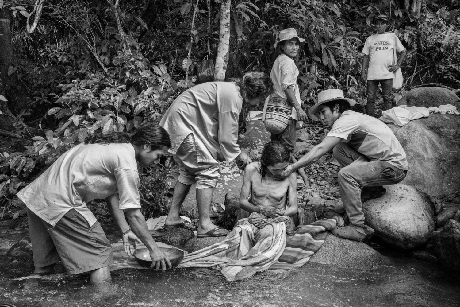 Young people from the Wiwa tribe are assisting a Mamo (spiritual guide) in the Kogui community, currently undergoing treatment in Gomake, Sierra Nevada de Santa Marta, in 2020. Mamos serve as both spiritual and political authorities. Through divination, they determine the spiritual responsibilities that each community member must fulfill to ensure harmony within their activities and maintain balance within their families, the community, and Mother Nature. Image by Roberto Maccariello.