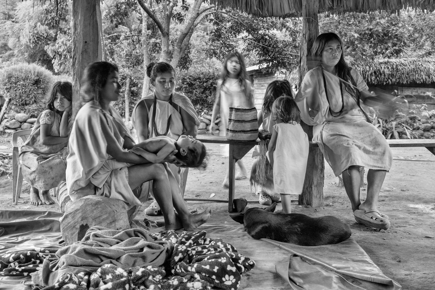Women, girls and children from the Wiwa tribe gather to weav and play together, Sierra Nevada De Santa Marta, Colombia, 2020. Weaving is regarded as a spiritual activity that helps focus the mind. Each "mochila" is created with a specific spiritual intention. Through conscious thought, the community believes the object can be infused with the energy needed to fulfill its purpose. Image by Roberto Maccariello.