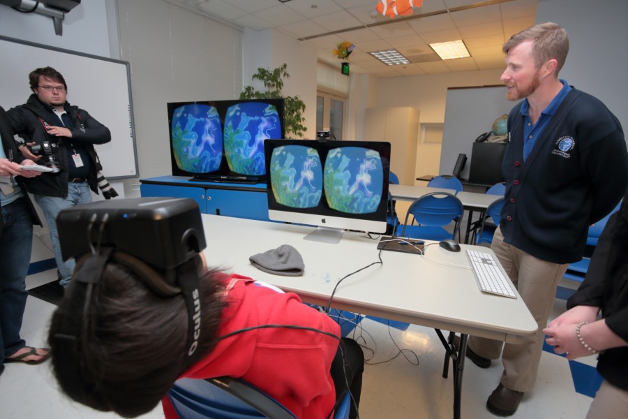 A Red Bank Middle School student wearing Oculus Rift looking up in the VR river simulation at the Tennessee Aquarium. Photo credit: Todd Stailey.