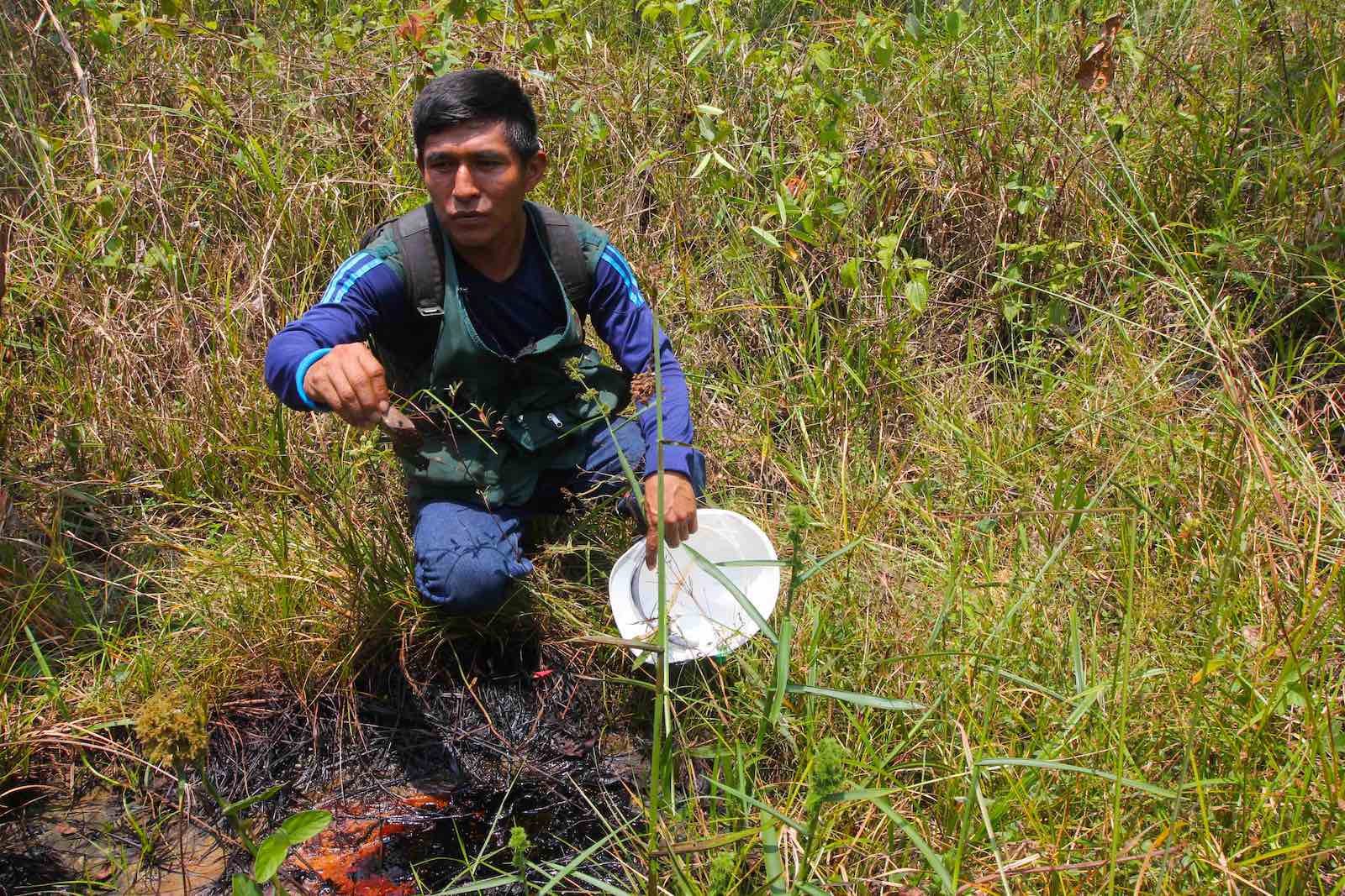 El monitor ambiental Elmer Hualinga examina un lugar donde el petróleo sale a la superficie en lo que solía ser el Lago Shanshacocha, un sitio contaminado que se drenó en lo que el estudio del PNUD llamó un esfuerzo inadecuado para la remediación. Foto: © Barbara Fraser.
