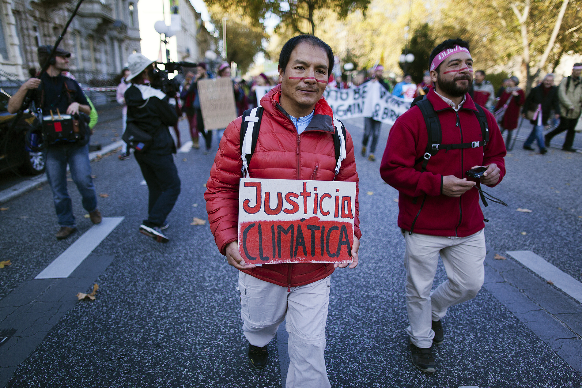 Saúl Luciano sostiene un cartel que dice Justicia Climática durante una marcha por el clima en el contexto de la COP23 de Bonn.