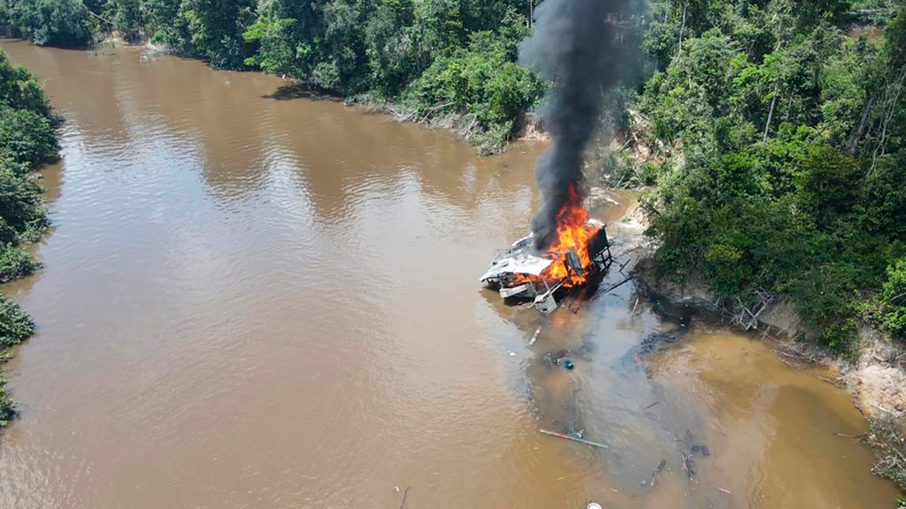 Draga minera en llamas a orillas de río en Amazonía