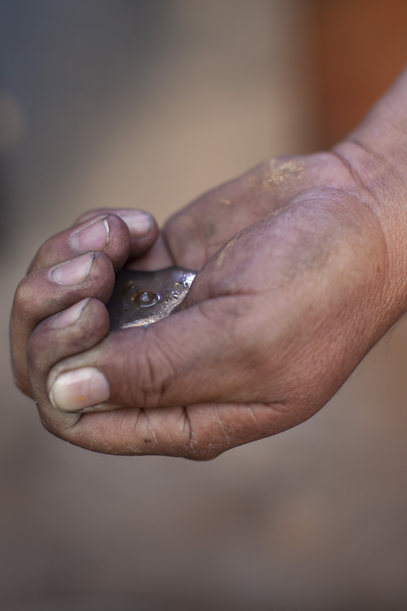Mercurio en estado líquido en mano de minero