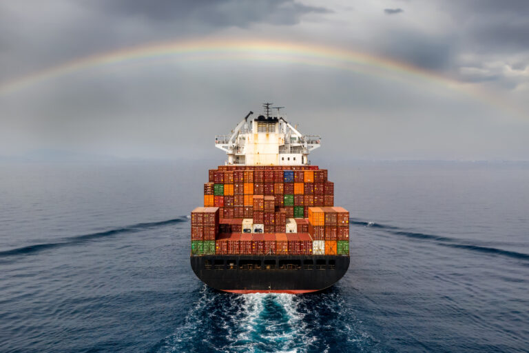 barco de comercio navegando con arcoiris de fondo