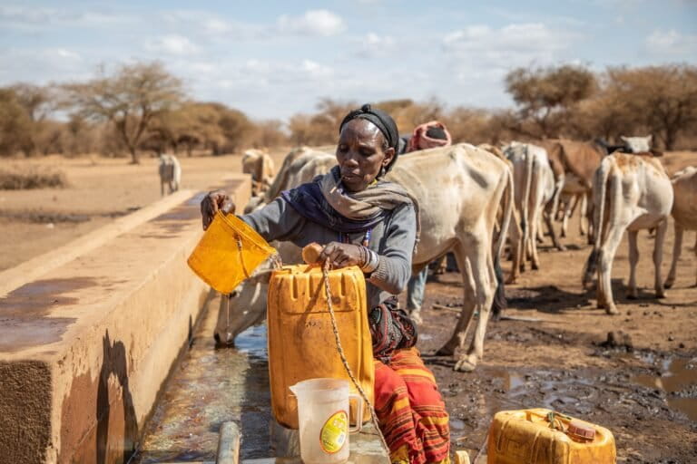 Mujer recolecta agua en bidones