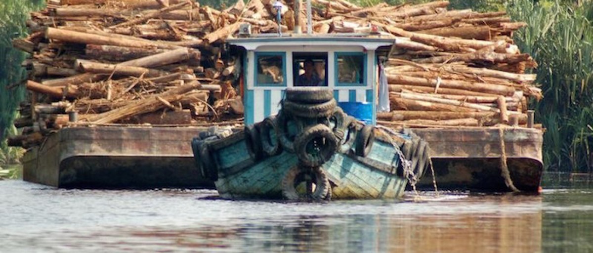 Boat towing a barge with timber in Senegal. Image courtesy ISS Africa (CC BY-4.0)