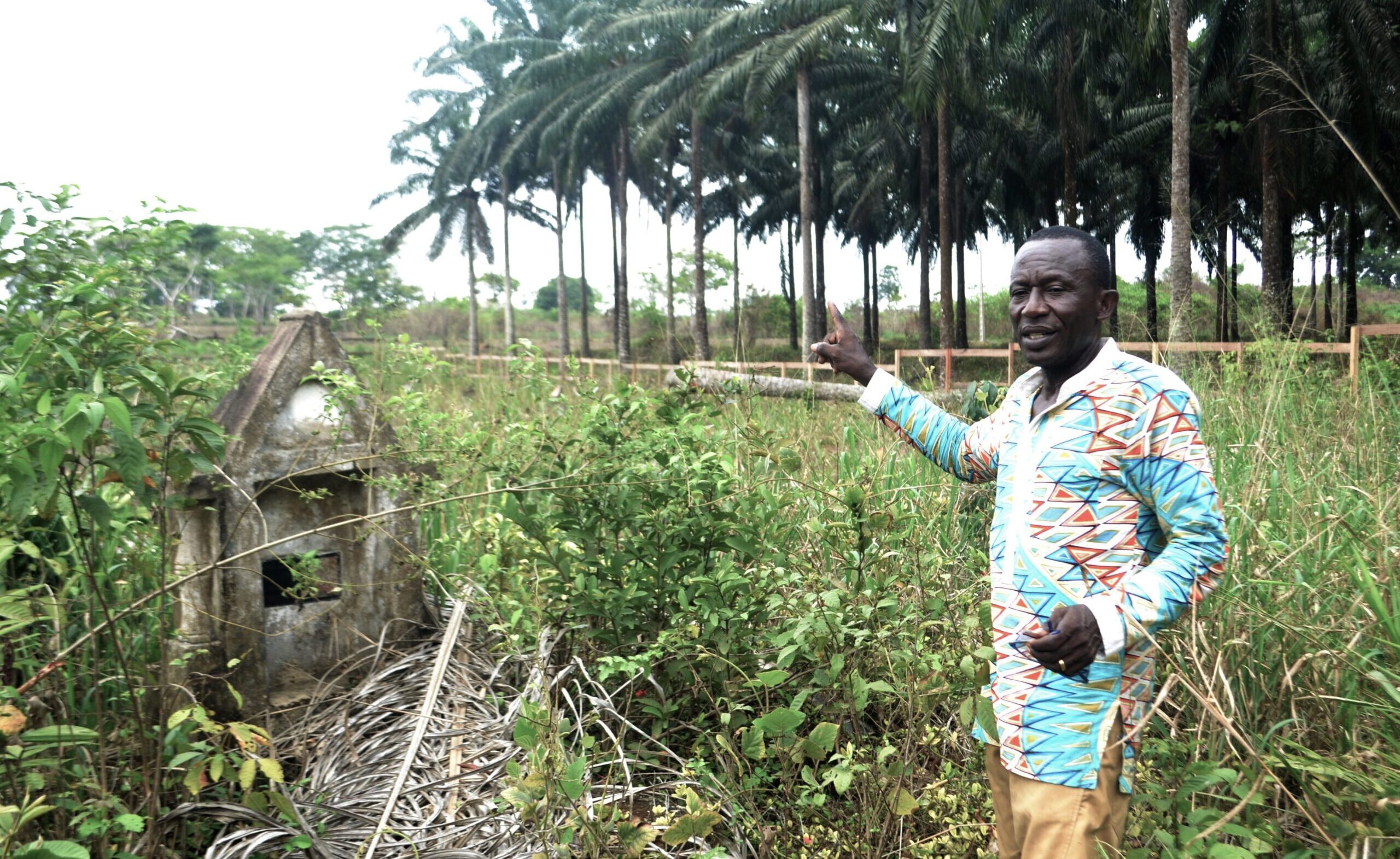 L’activiste Emmanuel Elong au pied d’une tombe ancestrale sur le site sacré de Bayong Mbonjo. Photo de Yannick Kenné.