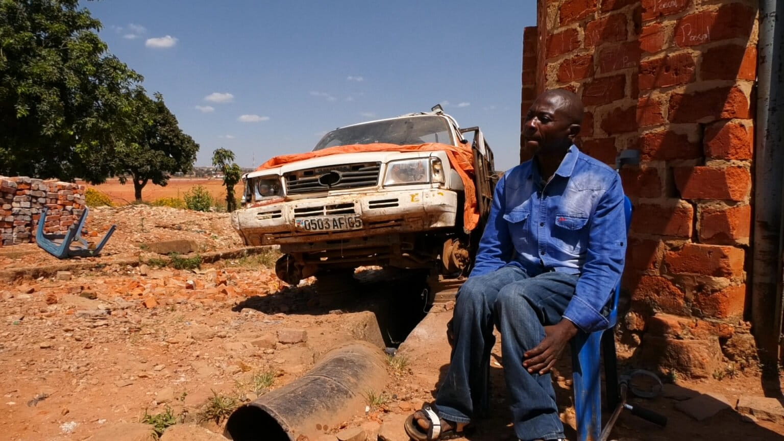 Adélard Makonga, un résident qui a refusé de partir et d’être délocalisé, est assis sur le site minier de la Gécamines. Il a exigé une « délocalisation légale » et une meilleure compensation pour la relocation. Photo d’Eric Cibamba