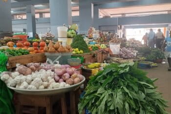 Des denrées alimentaires composées de fruits et légumes exposés dans un marché. Image de DiHM via Wikimédia Commons (CC BY-SA 4.0).