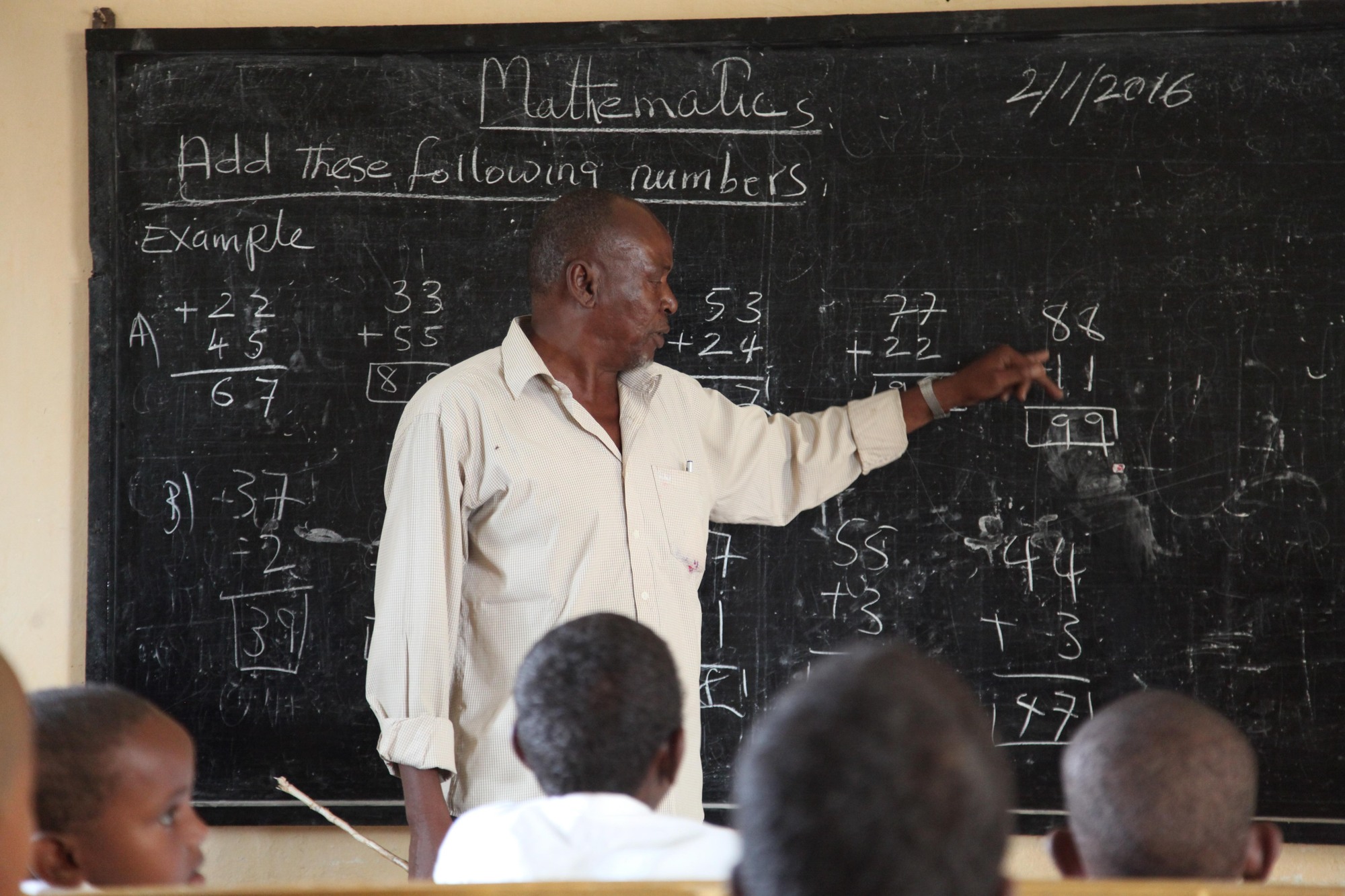 Un enseignant donne un cours de mathématiques à l'école primaire et secondaire de Ganane, à Kismayo, en Somalie. Image de AMISOM Public Information via Wikimédia Commons (Domaine public).