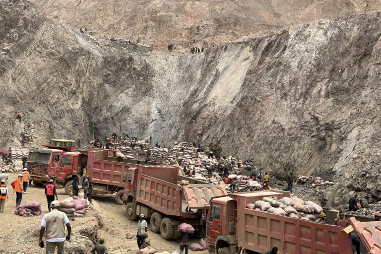 Des camions dans le site minier de Shabara chargés de sacs de minerais. Image de Electronics Watch via Flickr (CC BY-NC 2.0).
