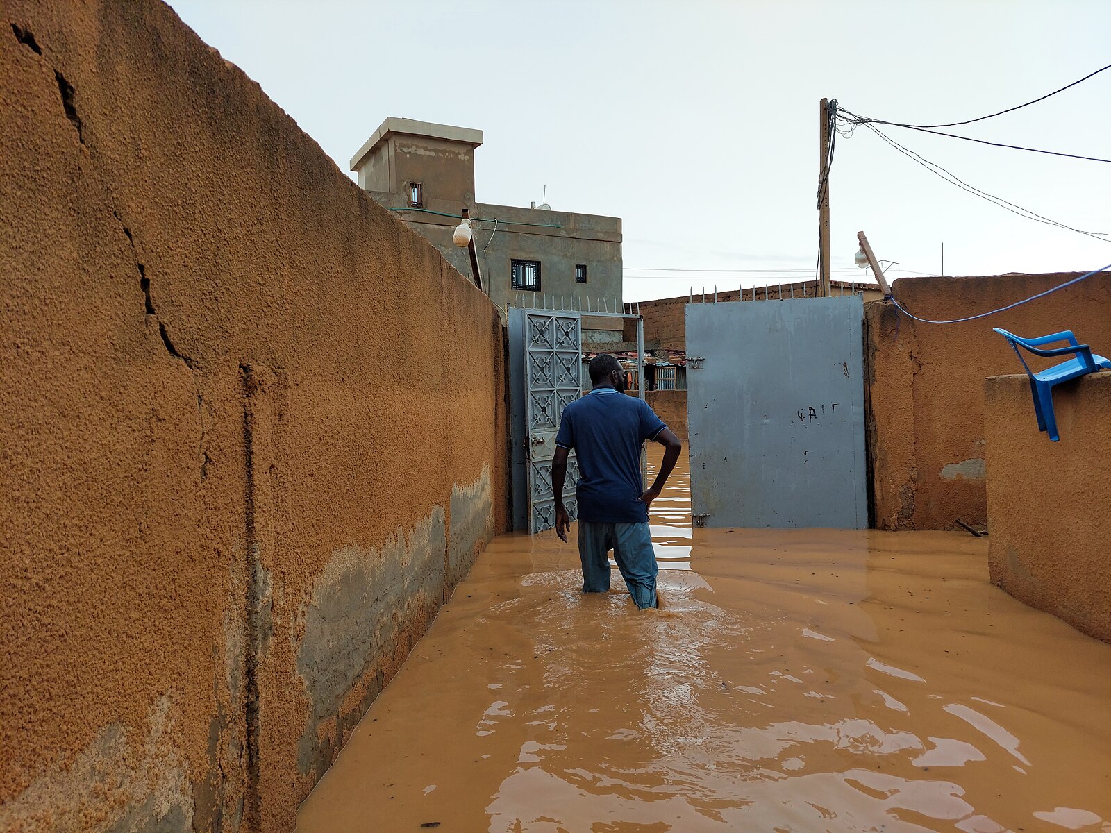 Un locataire les pieds dans l'eau après de fortes pluies. Image de Faride.boureima via Wikimédia Commons (CC BY-SA 4.0).