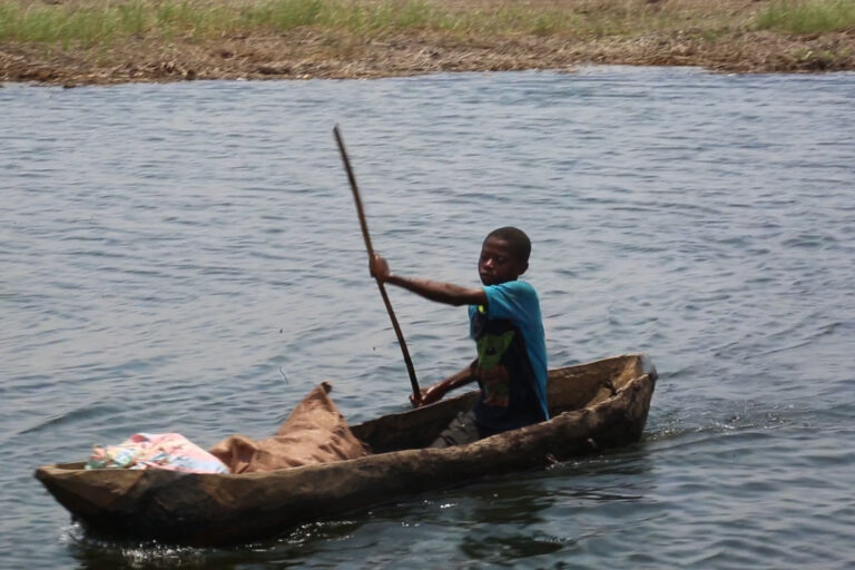 Un enfant sur le rivage, en provenance du champ sur la rive gauche du lac Kando en RDC. Image de Didier Makal pour Mongabay.