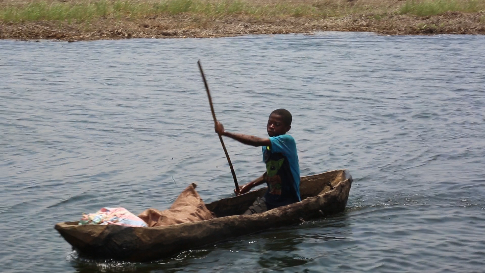 Un enfant sur le rivage, en provenance du champ sur la rive gauche du lac Kando en RDC. Image de Didier Makal pour Mongabay.