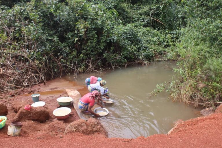 Des femmes en train de chercher de l’eau dans un étang, eau servant également à abreuver le bétail dans les zones de pâturages entourant les plateaux bauxitiques. Image de Yannick Kenné pour Mongabay.
