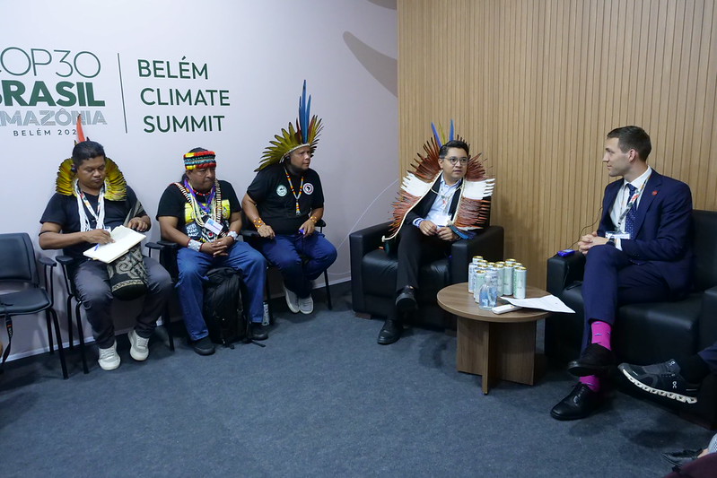 Le ministre norvégien du Climat et de l’Environnement, Andreas Bjelland Eriksen, échange avec des dirigeants autochtones du Brésil, lors de la COP30. Image de Klima- og miljøde via Flickr (CC BY-NC-ND 4.0).