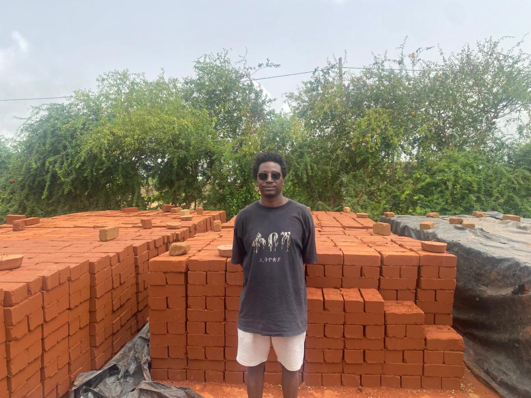 Des briques en terre sont rangées en files méticuleuses, prêtes à sécher. Image de Ndiémé Faye pour Mongabay.