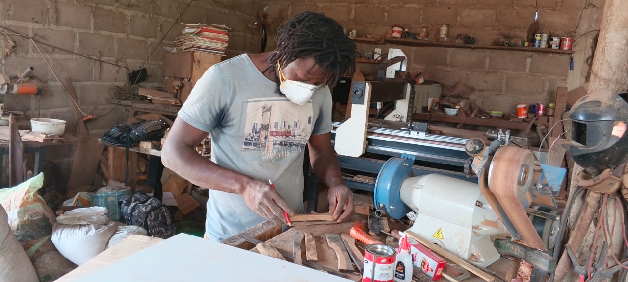 Dans son atelier, Soumaila Kanla assemble des pièces de bois mort pour donner forme à ses créations artisanales. Image de Hadepté Da pour Mongabay.