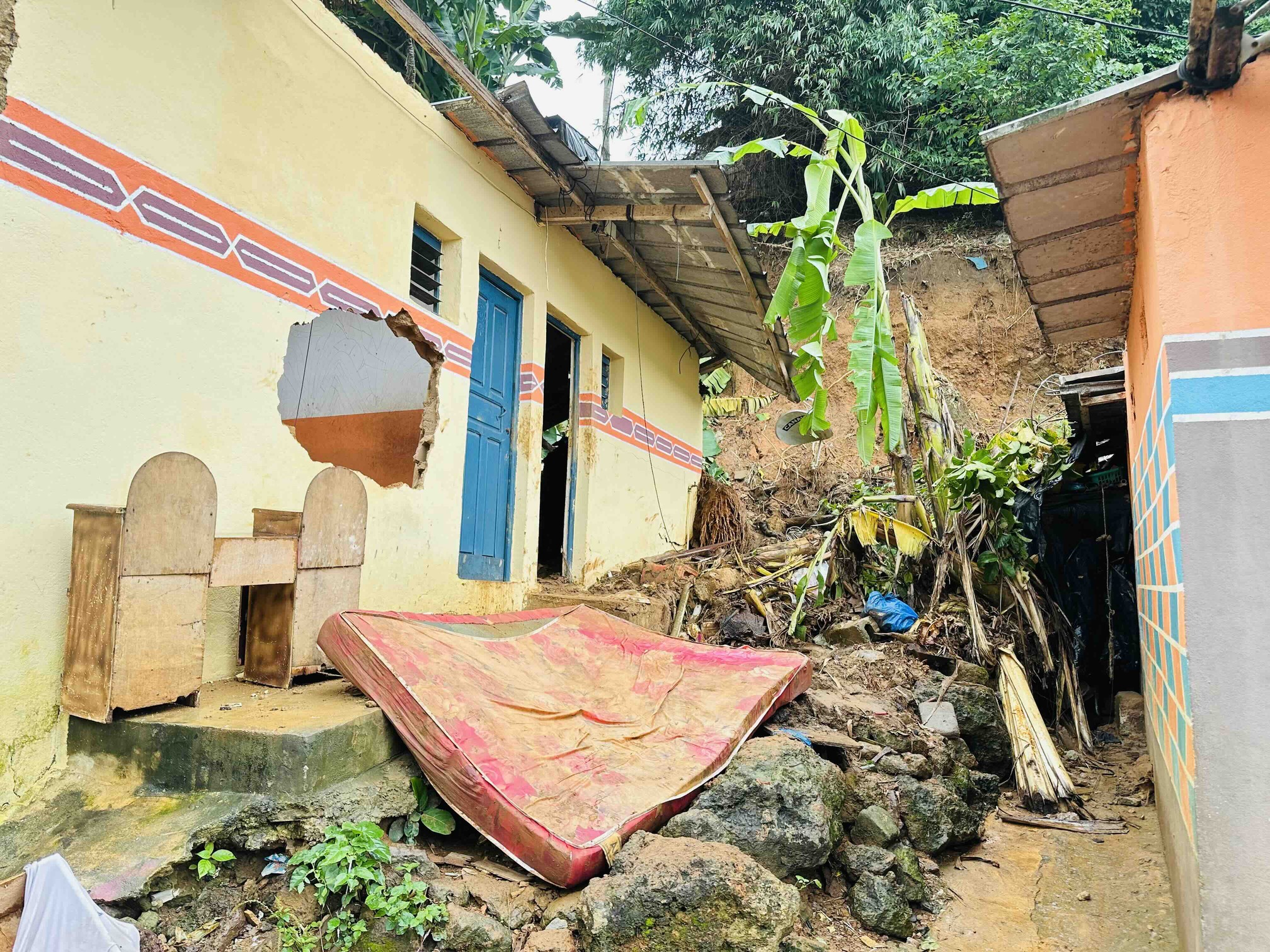 Des débris et des effets personnels devant une habitation située au pied de la pente touchée par le glissement de terrain à Nématoulaye, dans la commune d’Attécoubé, à Abidjan, en RCI. Image de Ella Djiguimde pour Mongabay.
