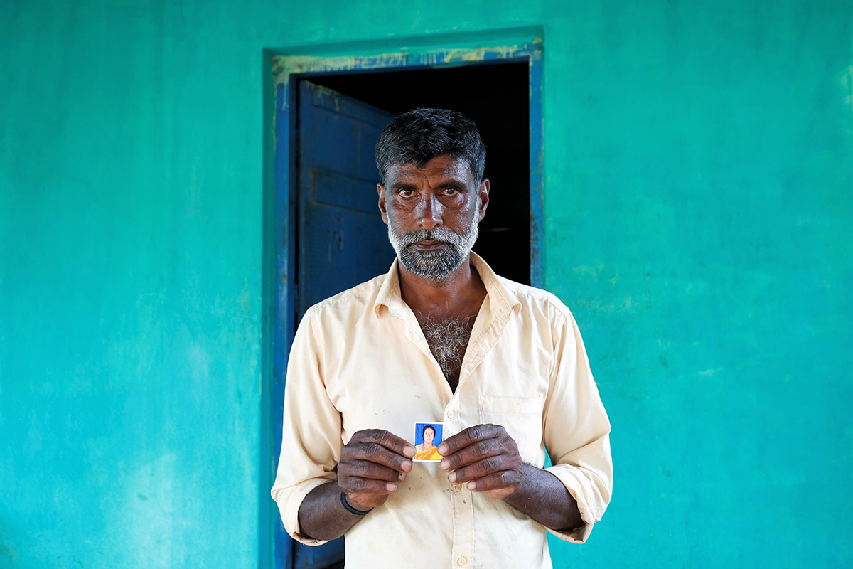 Ganesh V.S., 51, husband of Sujatha, 40, poses with her photo in Chowdikatte village. Sujatha died due to renal failure caused by complications following a bite from Russell’s viper. Photo by Abhishek N. Chinnappa/Mongabay.