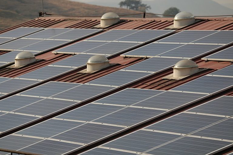 Image shows solar panels on top of a building in India