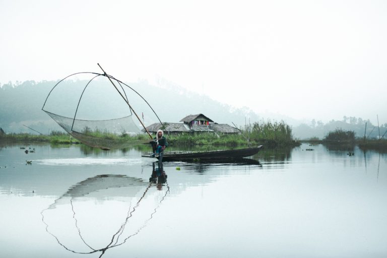 A fisherwoman pulling up her Chinese net using the traditional Khu-il Chingba method in front of a homestay. Photo by Victor Ningthoujam.