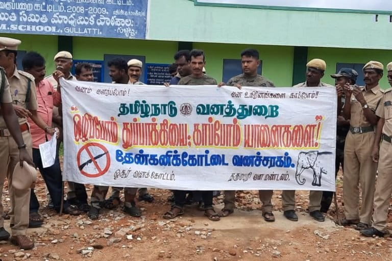 Image shows a group of people wearing police uniforms and holding up a banner