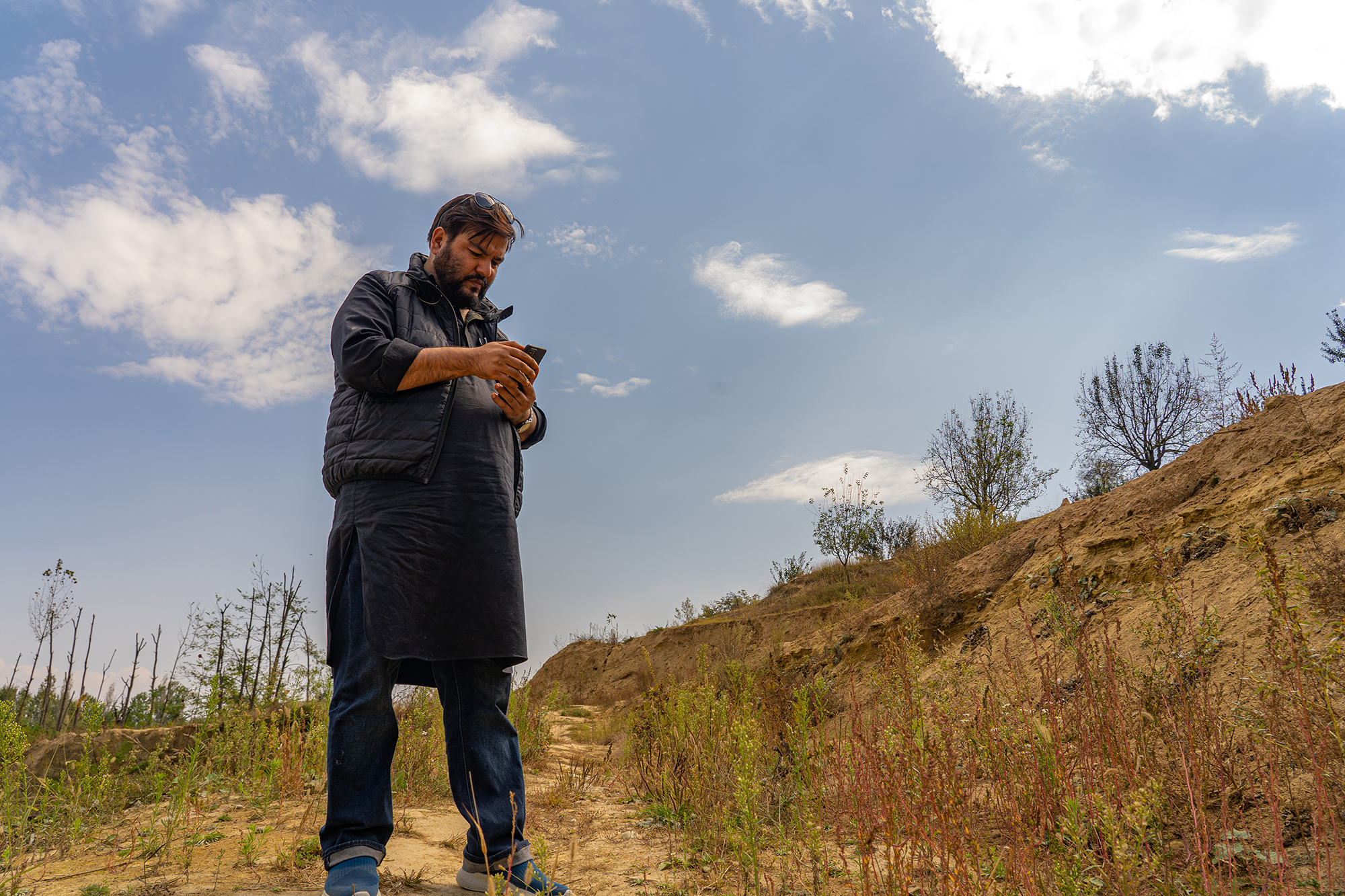 Activist Raja Muzaffar Bhat in a patch of land where karewas was mined. He highlights that karewas need conservation for their geological and ecological value. Photo by Shaz Syed/Mongabay.