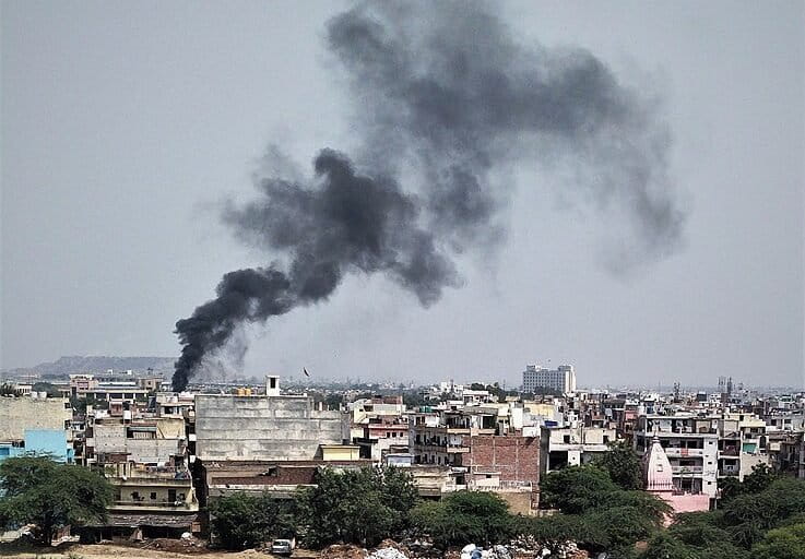 Image shows black smoke rising above a city in India