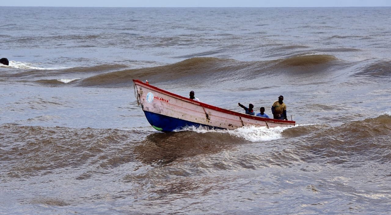 Fishers land a small boat at Muthalappozhi harbour. Photo by Sajith Remady.