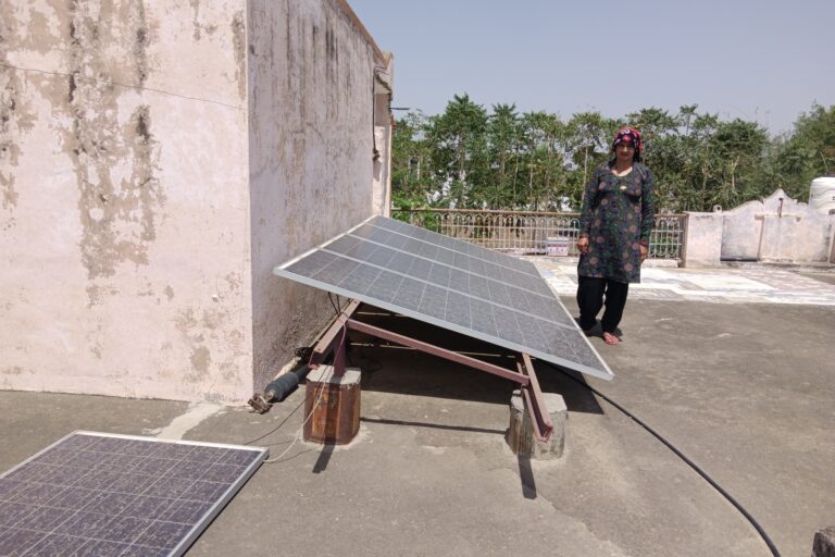 Bulesh Devi showing solar panel at her home, many of which broke because of heavy winds. These solar panels were originally meant for solar pumps and are being used in the house after the solar pumps stopped working. Photo by Parul Kulshrestha.