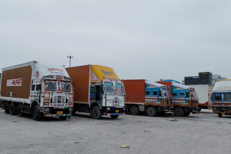 Image shows trucks in a parking lot in India