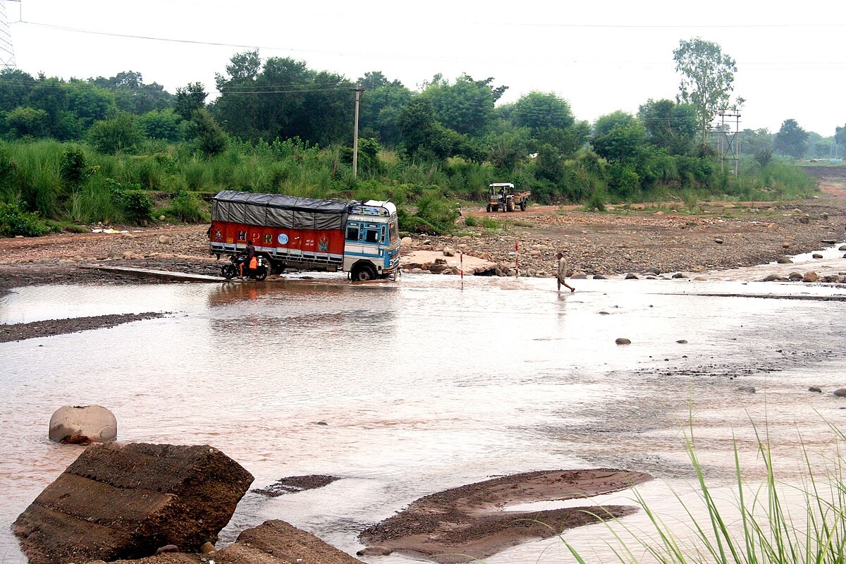 A truck trying to cross the river in Himachal Pradesh.