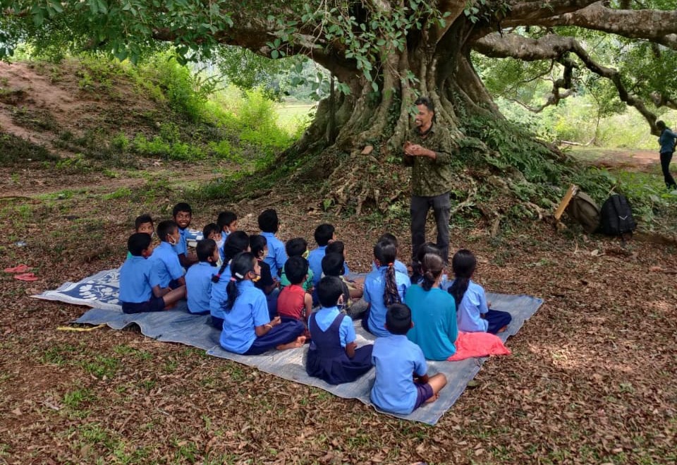 Dinesh Holla engages with children in the Western Ghats. Image courtesy of Sahyadri Sanchaya.
