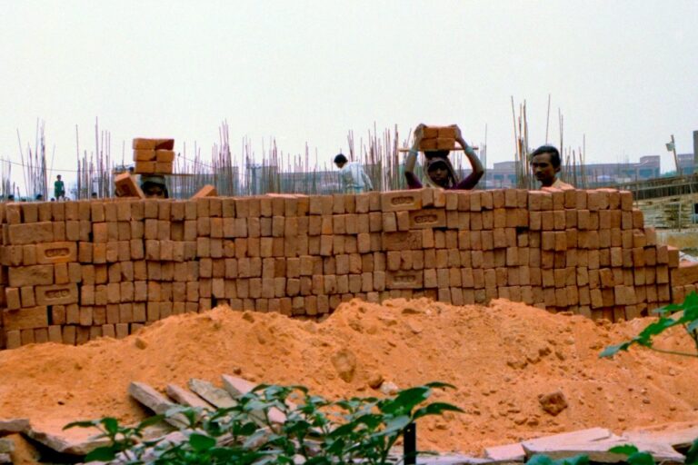 Construction workers stack bricks. Image by R Barraez D'Lucca via Flickr (CC BY 2.0).