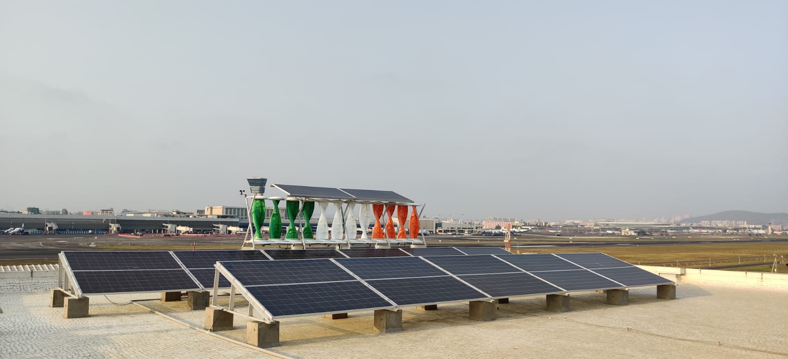 A wind-solar hybrid energy system installed at Mumbai airport. Image by WindStream Energy Technologies PVT LTD via Wikimedia Commons (CC BY 4.0).