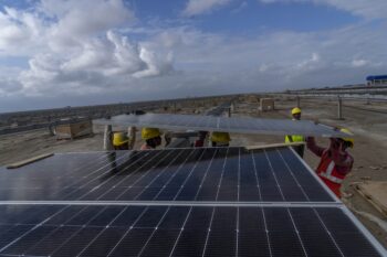 Workers install solar panels in Gujarat. (AP Photo/Rafiq Maqbool)