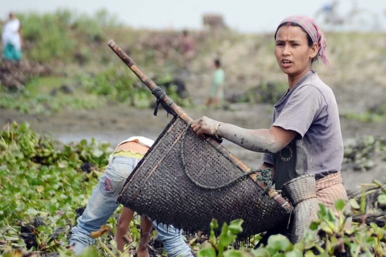 An indigenous woman from Assam during community fishing. Current conservation efforts often exclude and marginalise local and Indigenous peoples, writes the author. Image by Diganta Talukdar via Wikimedia Commons (CC-BY-SA-4.0).