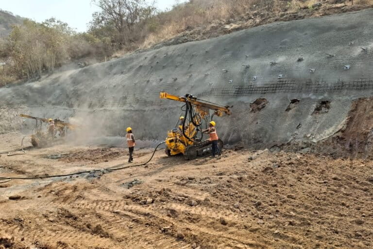 Workers conduct slope stabilisation measures, which include installing a wire mesh, rock anchors, and self drilling anchor bars along NH44. Image by NHIDCL.