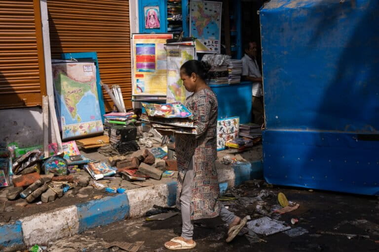 A small book stall owner saw her entire shop washed away on the night of September 22. She managed to rescue a few items and is now storing them, hoping to clean and resell them. Image by Subhrajit Sen.