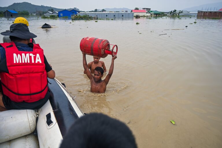 A boy carries a gas cylinder to a rescue boat from his inundated kitchen in Mantripukhri, Imphal East district in June 2024. Image by Ningthoujam Victor.