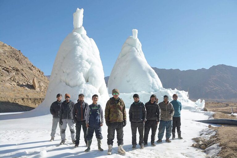 Students of the he Himalayan Institute of Alternatives, co-founded by Wangchuk in Ladakh, stand in front of their ice stupa project. Image by Crb43 via Wikimedia Commons (CC BY-SA 4.0).