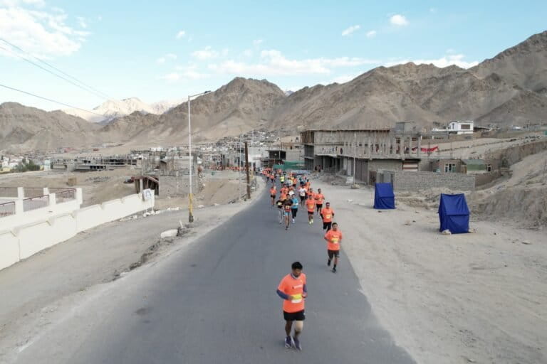 Runners en route at the Ladakh Marathon. Dry toilets (in blue tents) have been placed along the marathon route. Image courtesy of Ladakh Marathon.