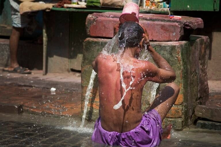 A man uses water to cool himself in the heat in Kolkata. Adaptation measures such as better water management, coastal protection and heat-resilience innovations are needed in cities to help societies adjust to climate impacts. An adaptation gap exists, between what countries are doing and what is needed to safeguard people and ecosystems. Representative image by Jorge Royan via Wikimedia Commons (CC BY-SA 3.0).